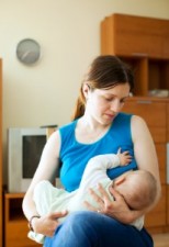 Mother breast feeding baby at home